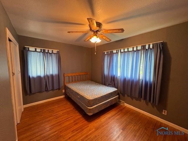 23695 E Second St, Grand Rapids, OH 43522 - bedroom featuring wood finished floors, multiple windows, baseboards, and ceiling fan