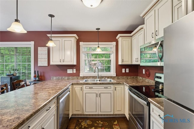 3480 Circle Dr, Delta, OH 43515 - kitchen featuring appliances with stainless steel finishes, a sink, cream cabinets, decorative light fixtures, and dark wood finished floors