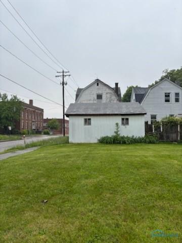 149 Oswald St, Toledo, OH 43605 - view of side of home with a lawn, a chimney, and a gambrel roof