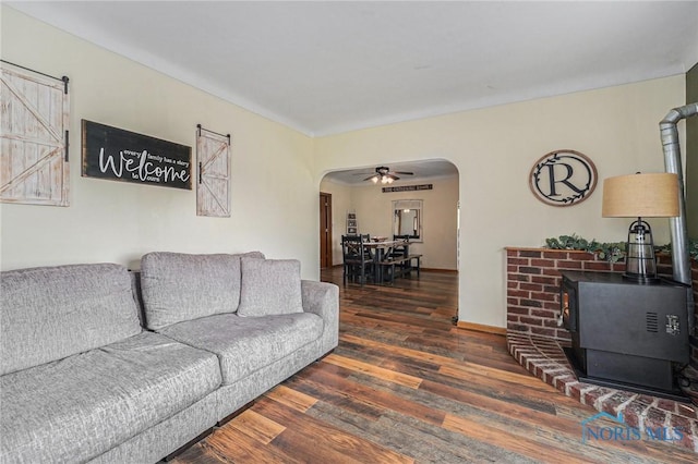22227 US Highway 20a, West Unity, OH 43570 - living room featuring arched walkways, a wood stove, wood finished floors, and ceiling fan