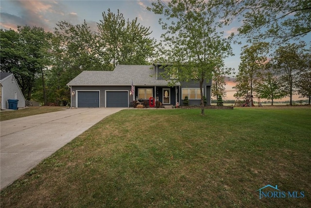 219 Illinois Dr, Bryan, OH 43506 - view of front of home featuring a garage, a lawn, driveway, and a porch