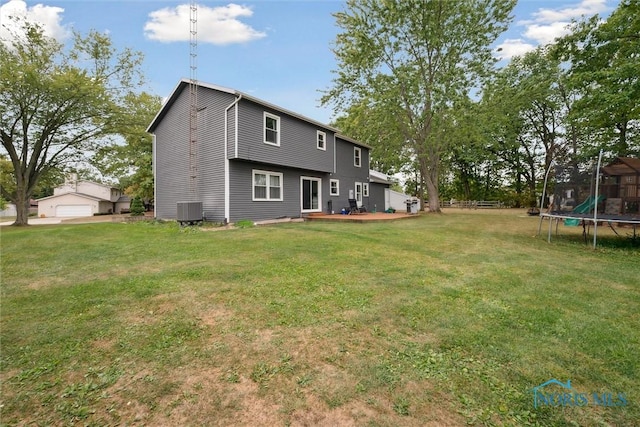 219 Illinois Dr, Bryan, OH 43506 - rear view of house featuring a trampoline, a yard, and central air condition unit