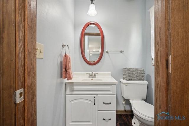 219 Illinois Dr, Bryan, OH 43506 - half bathroom featuring vanity, toilet, and wood finished floors