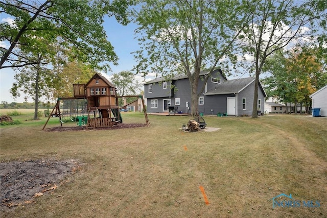 219 Illinois Dr, Bryan, OH 43506 - view of grassy yard with a playground and an outdoor fire pit