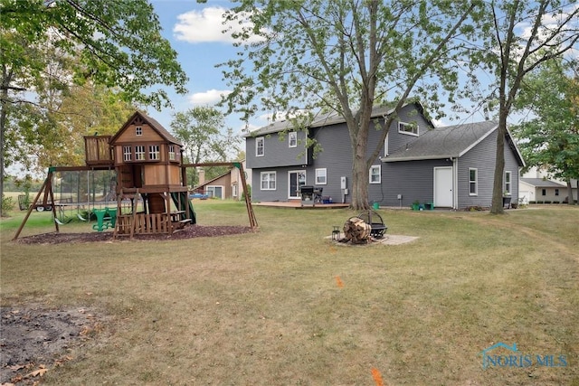 219 Illinois Dr, Bryan, OH 43506 - rear view of house with a playground, a fire pit, and a yard