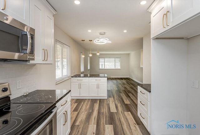 1048 Richland St, Maumee, OH 43537 - kitchen featuring stainless steel appliances, dark wood-style floors, white cabinets, tasteful backsplash, and dark stone countertops