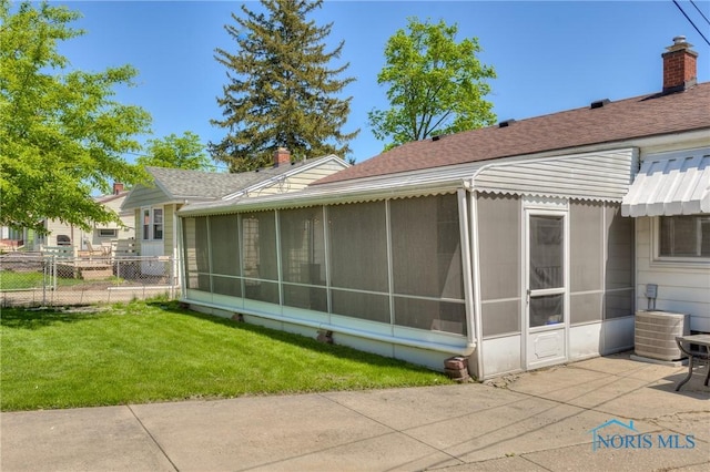 1367 Junior Dr, Maumee, OH 43537 - rear view of property featuring a sunroom, a chimney, roof with shingles, cooling unit, and a patio area