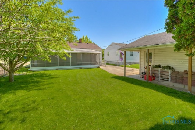 1367 Junior Dr, Maumee, OH 43537 - view of grassy yard featuring a sunroom and a patio