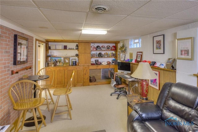 1367 Junior Dr, Maumee, OH 43537 - home office with a paneled ceiling, carpet, bar, and brick wall