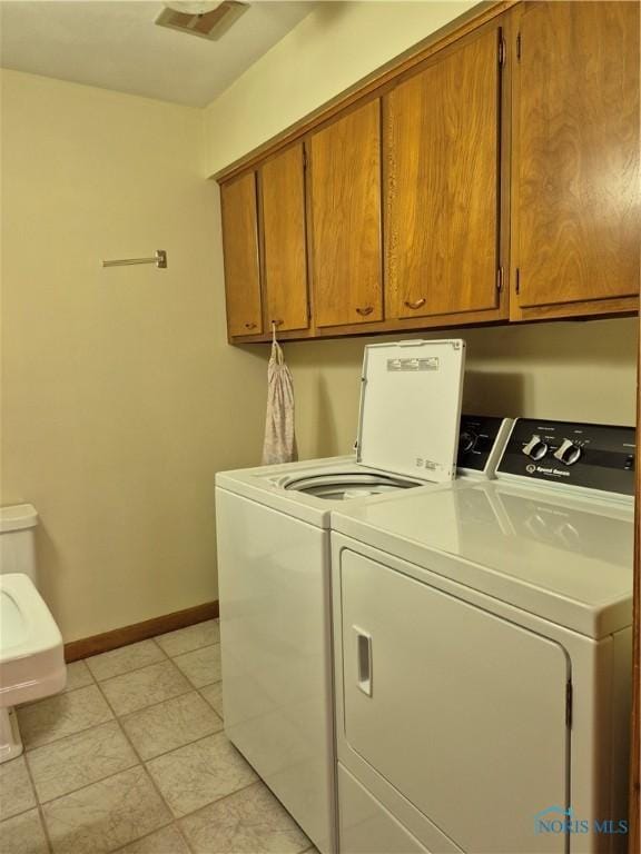 1100 Cherry Ln, Findlay, OH 45840 - laundry room with separate washer and dryer, baseboards, cabinet space, and light tile patterned floors