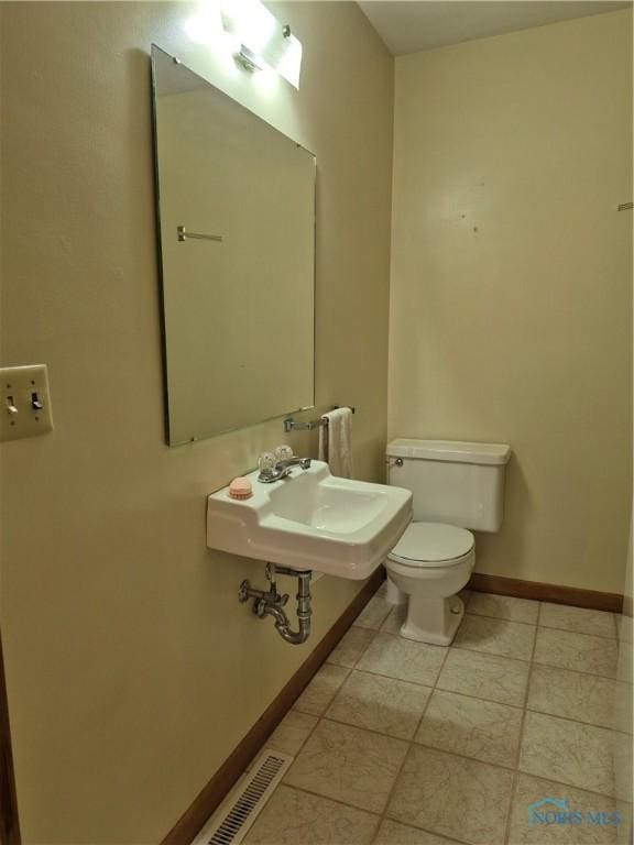 1100 Cherry Ln, Findlay, OH 45840 - bathroom with baseboards, a sink, toilet, and tile patterned flooring