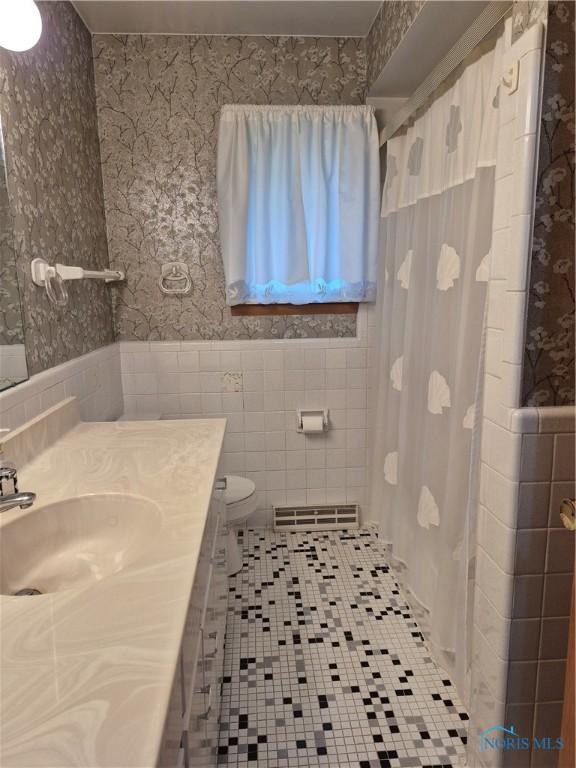 1100 Cherry Ln, Findlay, OH 45840 - full bath featuring wallpapered walls, tile walls, a wainscoted wall, vanity, and toilet