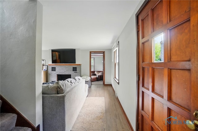 314 E 2nd St, Perrysburg, OH 43551 - living area featuring light wood-type flooring, a brick fireplace, and baseboards