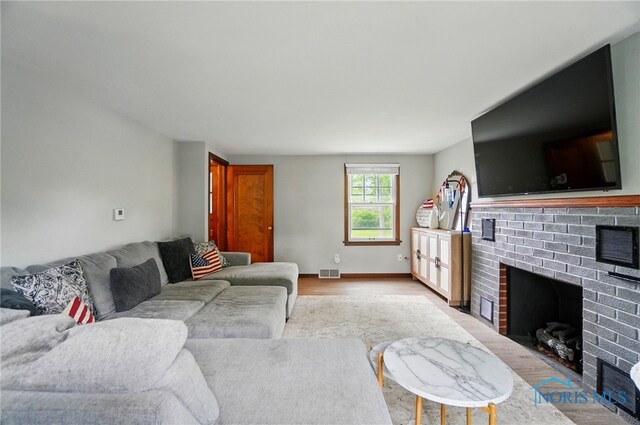 314 E 2nd St, Perrysburg, OH 43551 - living area with a brick fireplace, light wood finished floors, and baseboards