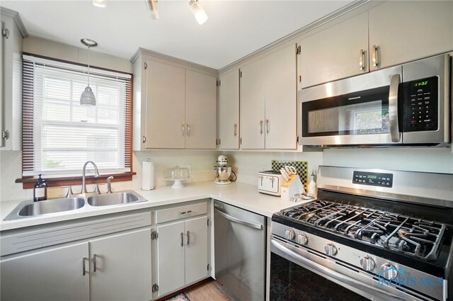 314 E 2nd St, Perrysburg, OH 43551 - kitchen featuring stainless steel appliances, a sink, light countertops, decorative light fixtures, and light wood-style flooring