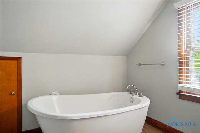 314 E 2nd St, Perrysburg, OH 43551 - full bath with vaulted ceiling, a soaking tub, healthy amount of natural light, wood finished floors, and baseboards