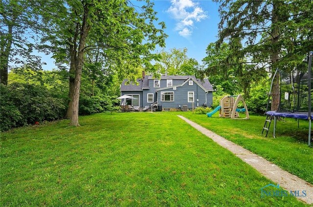 314 E 2nd St, Perrysburg, OH 43551 - view of green lawn with a trampoline and a playground