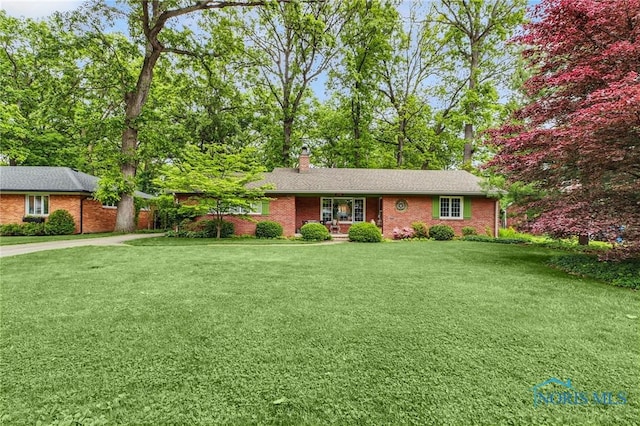 2742 Sandalwood Ave, Toledo, OH 43614 - ranch-style house with a front yard, a chimney, brick siding, and concrete driveway