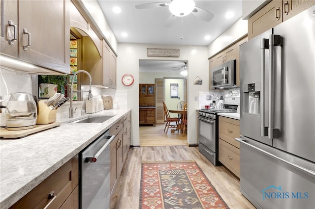 2742 Sandalwood Ave, Toledo, OH 43614 - kitchen featuring stainless steel appliances, a ceiling fan, a sink, light wood-style floors, and light countertops