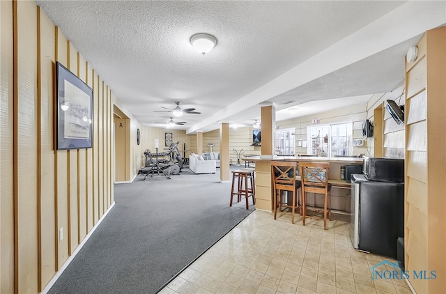 6640 Salisbury Rd Unit 212, Maumee, OH 43537 - bar area featuring black microwave, a textured ceiling, light colored carpet, and ceiling fan