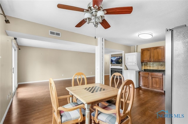 6640 Salisbury Rd Unit 212, Maumee, OH 43537 - dining room with stacked washing machine and dryer, ceiling fan, and dark wood-style flooring