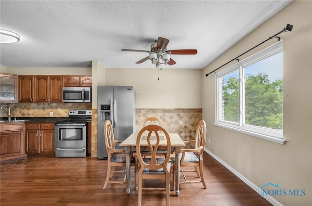 6640 Salisbury Rd Unit 212, Maumee, OH 43537 - kitchen featuring stainless steel appliances, brown cabinetry, a textured ceiling, a ceiling fan, and dark wood-style floors