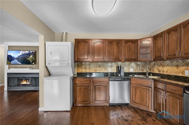 6640 Salisbury Rd Unit 212, Maumee, OH 43537 - kitchen with dishwasher, stacked washer / drying machine, dark wood-style flooring, tasteful backsplash, and dark stone countertops