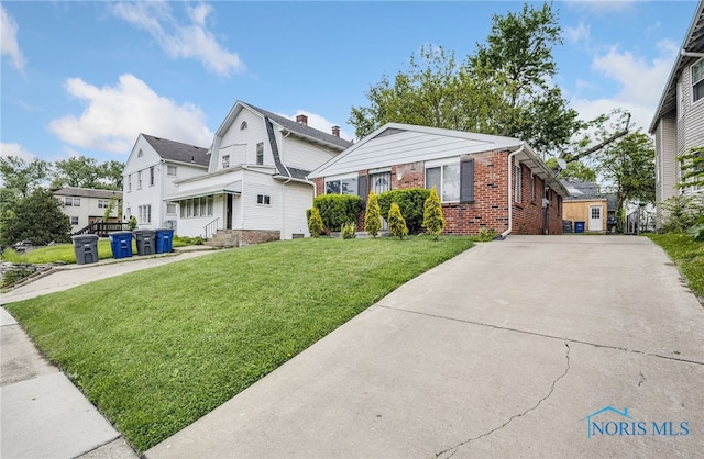 2146 Alvin St, Toledo, OH 43607 - view of front of house with brick siding, a front yard, and a residential view