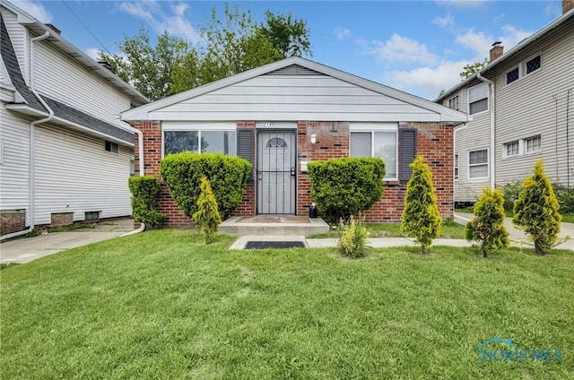 2146 Alvin St, Toledo, OH 43607 - view of front of home with brick siding and a front lawn