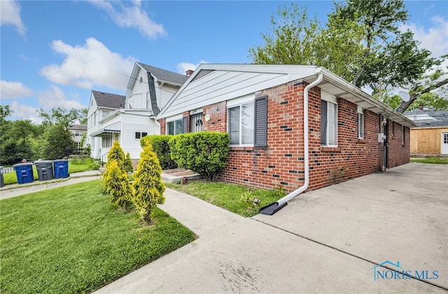 2146 Alvin St, Toledo, OH 43607 - view of home's exterior with brick siding and a lawn