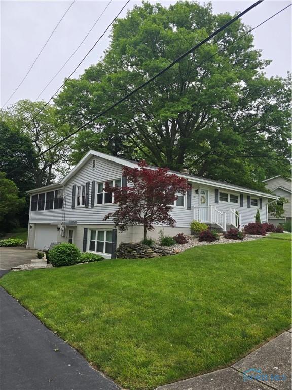 1501 Tiffin Rd, Fremont, OH 43420 - view of front facade featuring an attached garage, driveway, and a front lawn