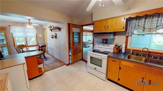 1501 Tiffin Rd, Fremont, OH 43420 - kitchen with white electric range oven, ceiling fan, a sink, under cabinet range hood, and dark countertops