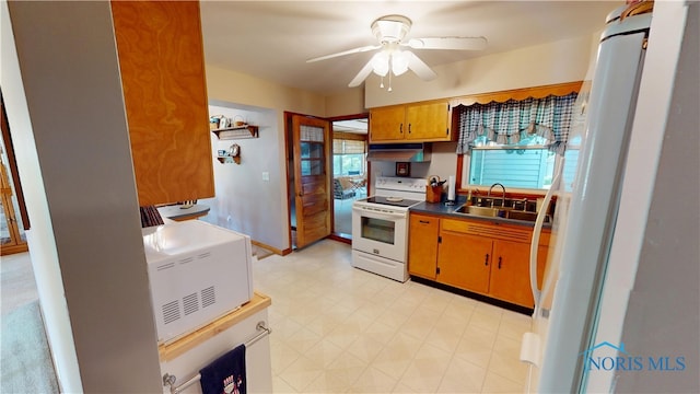 1501 Tiffin Rd, Fremont, OH 43420 - kitchen featuring white appliances, a sink, under cabinet range hood, ceiling fan, and dark countertops