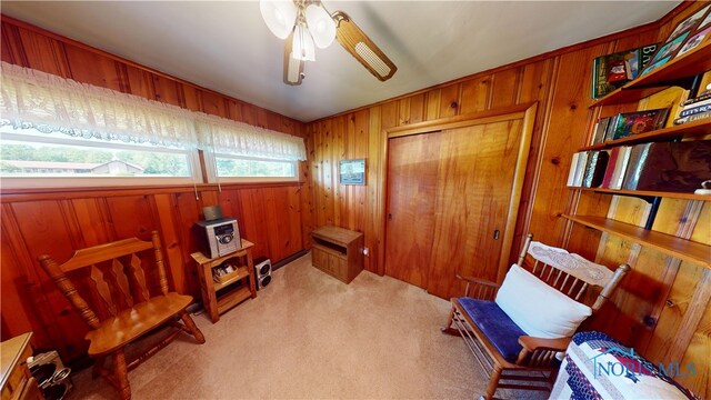 1501 Tiffin Rd, Fremont, OH 43420 - living area with carpet flooring, wood walls, and ceiling fan