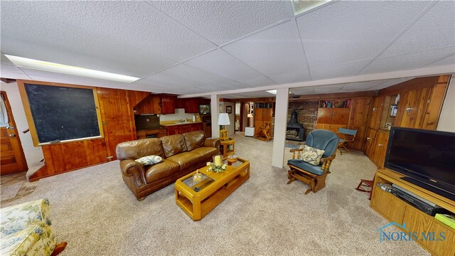 1501 Tiffin Rd, Fremont, OH 43420 - living area with wood walls, carpet floors, a paneled ceiling, and a wood stove