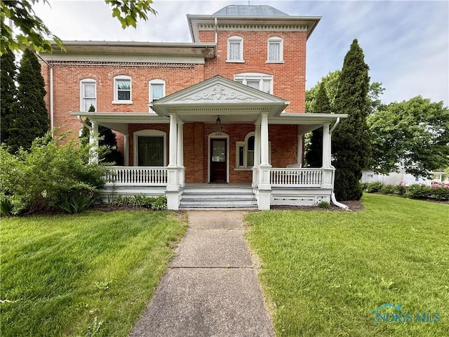 206 W Main St, Fayette, OH 43521 - view of front of property with brick siding, a front yard, and a porch