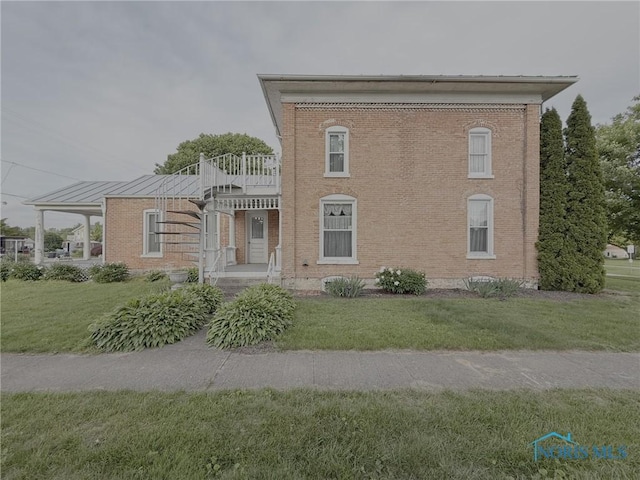 206 W Main St, Fayette, OH 43521 - view of front of home featuring a front yard, brick siding, and a balcony