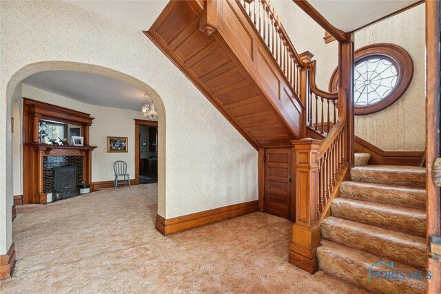 206 W Main St, Fayette, OH 43521 - stairs featuring arched walkways, carpet flooring, a fireplace with flush hearth, and baseboards