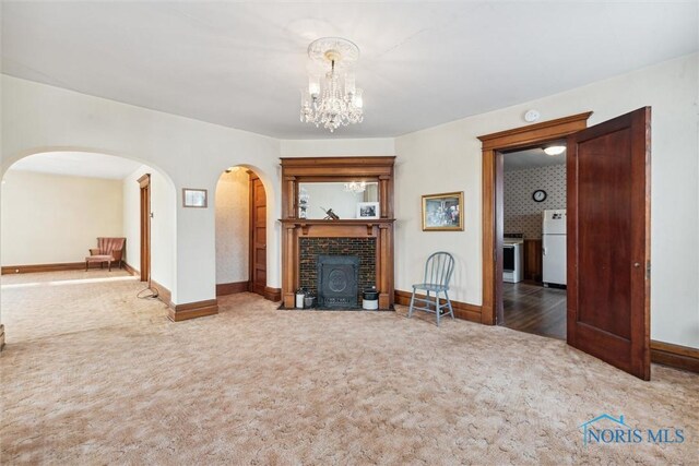 206 W Main St, Fayette, OH 43521 - living room featuring carpet flooring, a tiled fireplace, arched walkways, and baseboards