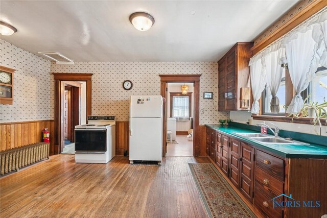 206 W Main St, Fayette, OH 43521 - kitchen with white appliances, wallpapered walls, a sink, a wainscoted wall, and light wood-type flooring