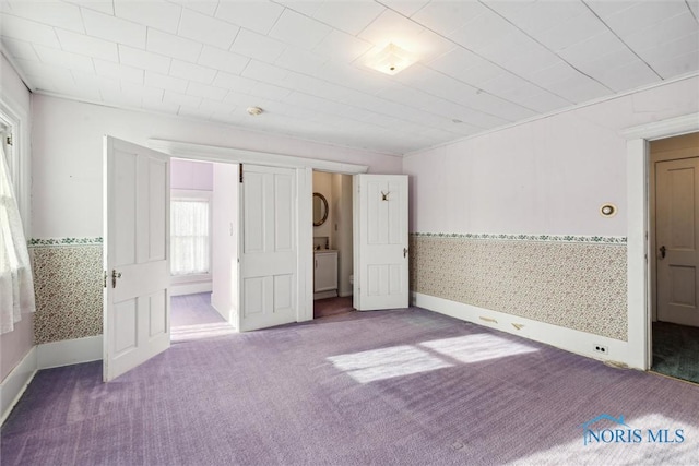 206 W Main St, Fayette, OH 43521 - unfurnished bedroom featuring stacked washer and clothes dryer, carpet, wallpapered walls, and baseboards
