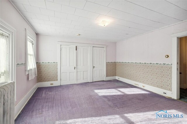 206 W Main St, Fayette, OH 43521 - unfurnished bedroom with multiple windows, wallpapered walls, carpet flooring, a closet, and baseboards