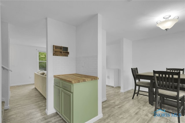 4238 Knollcrest Rd, Toledo, OH 43611 - kitchen with green cabinetry, butcher block countertops, light wood-style floors, baseboards, and decorative backsplash