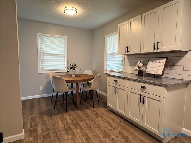 210 W William St, Maumee, OH 43537 - dining room with baseboards, dark wood-style floors, and a textured ceiling