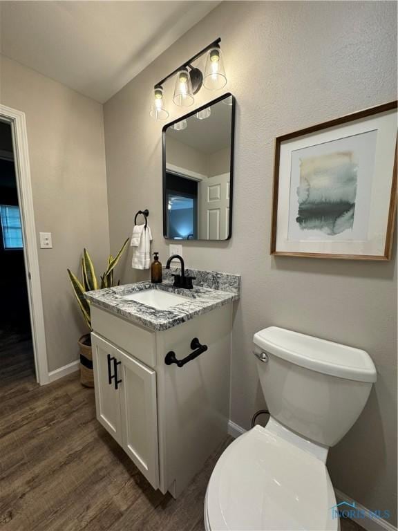 210 W William St, Maumee, OH 43537 - bathroom with vanity, wood finished floors, baseboards, and toilet