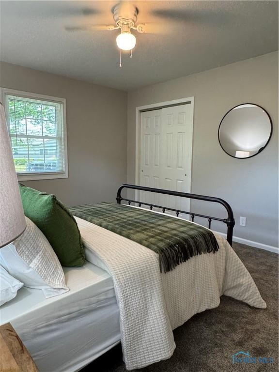 210 W William St, Maumee, OH 43537 - bedroom featuring baseboards, a closet, ceiling fan, and dark carpet