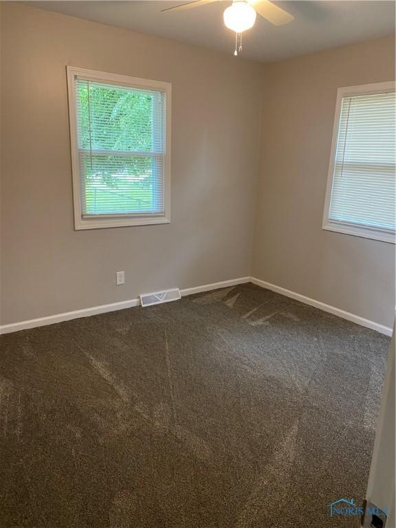 210 W William St, Maumee, OH 43537 - unfurnished room with ceiling fan, baseboards, and dark colored carpet