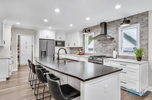 2714 W Rockridge Cir, Toledo, OH 43606 - kitchen featuring wall chimney exhaust hood, premium appliances, a sink, tasteful backsplash, and recessed lighting