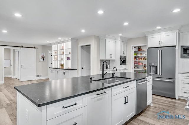 2714 W Rockridge Cir, Toledo, OH 43606 - kitchen with stainless steel appliances, a sink, open shelves, a barn door, and dark countertops