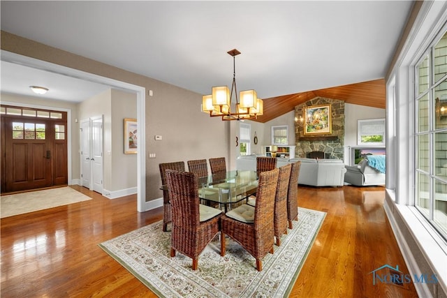 1860 Watermill Ln, Perrysburg, OH 43551 - dining area with a chandelier, wood finished floors, lofted ceiling, baseboards, and a stone fireplace